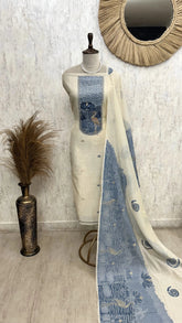 Mannequin wearing a blue and white patterned dress with a decorative mirror and vase in the background.